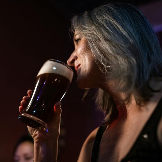 low angle photo of woman drinking a beer
